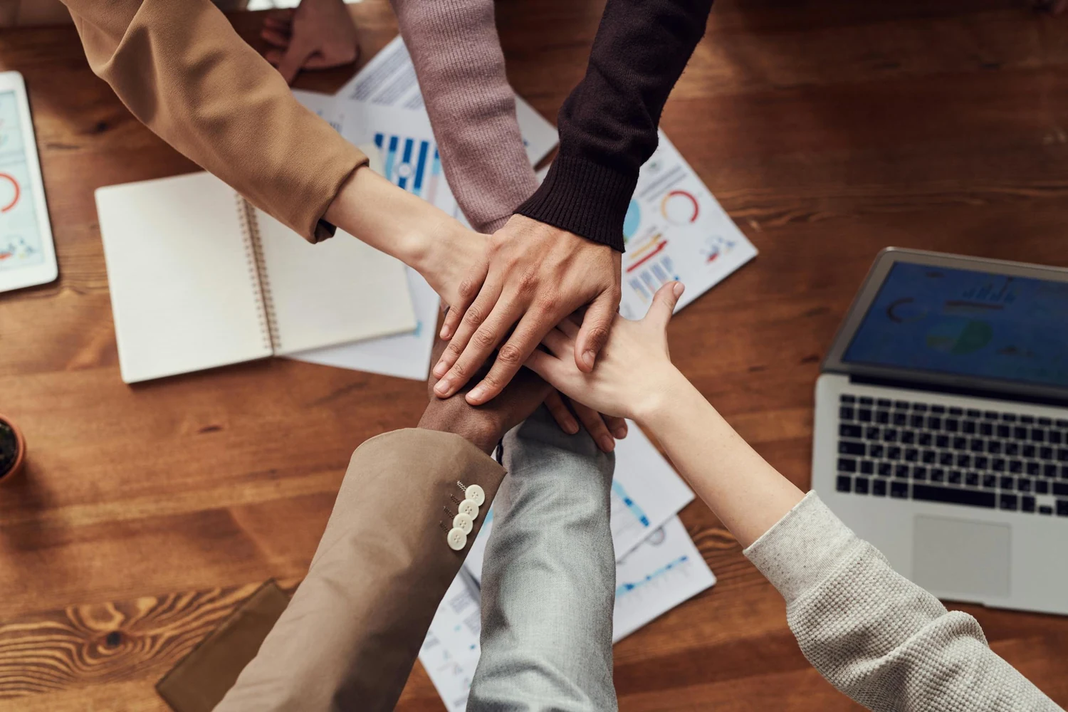 Team hands collaborating over launch materials